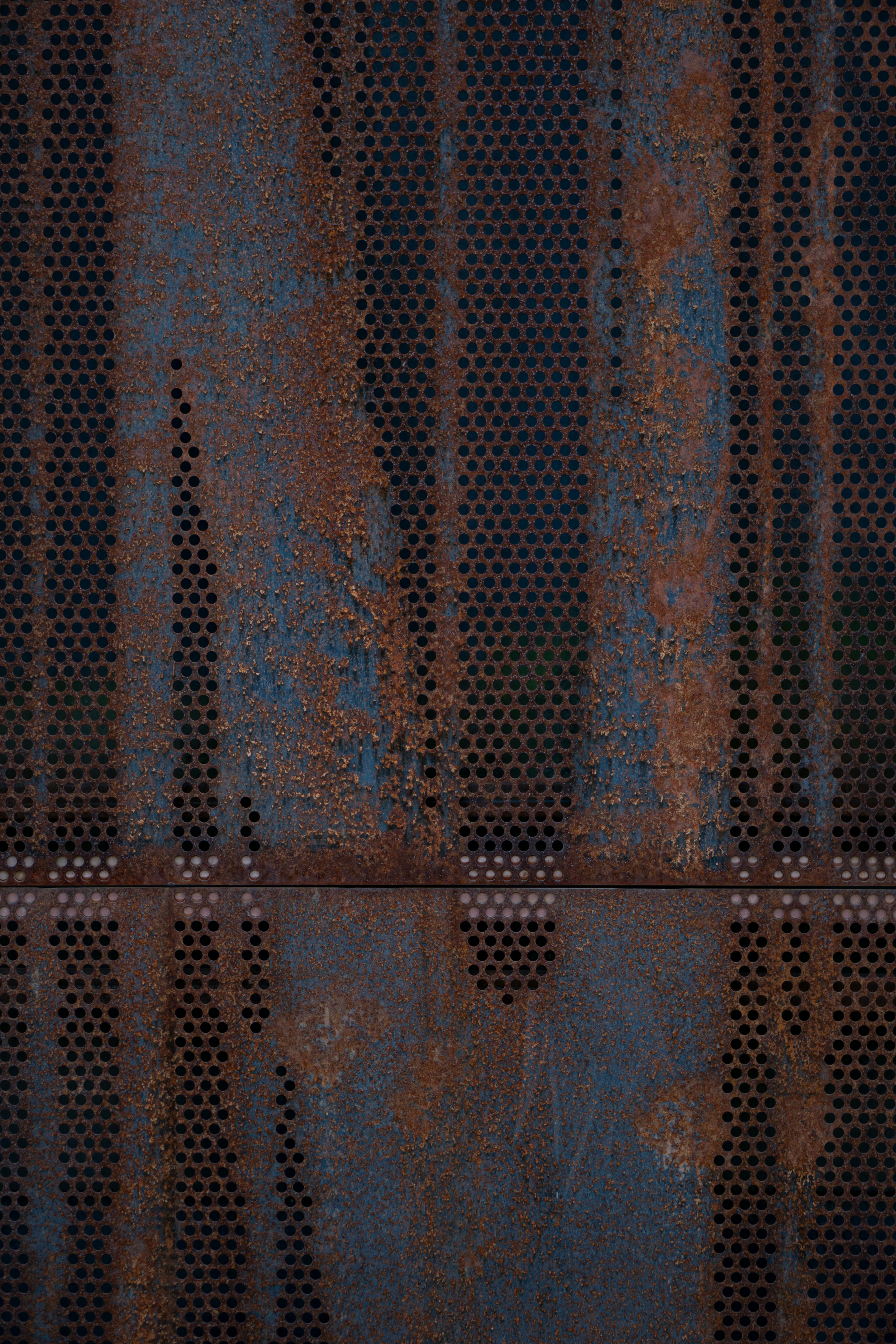 Kostenlos Nahaufnahme einer verrosteten und perforierten Metalloberfläche, die Textur und Farbe zeigt. Stock-Foto