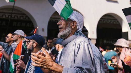 Free Old man participates in a peaceful protest with Palestinian flags in Rabat, Morocco. Stock Photo