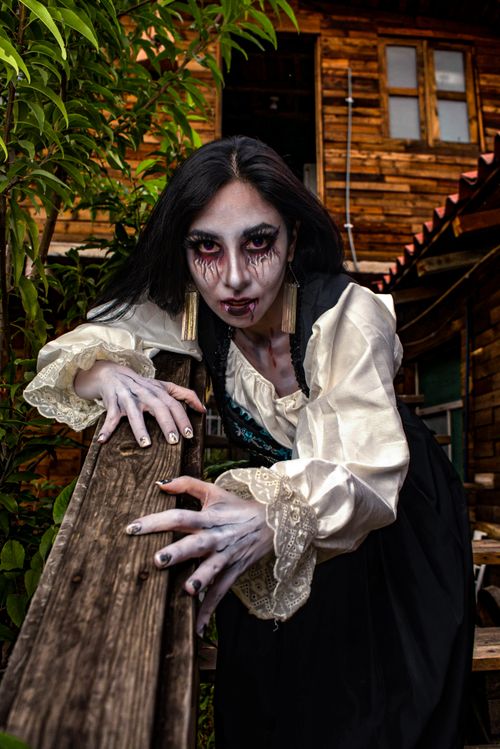 Free Frightening woman with spooky makeup in a creepy costume outdoors capturing Halloween spirit. Stock Photo