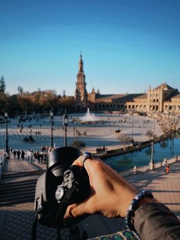 Photographer capturing the iconic Plaza de España, Sevilla, on a bright day.