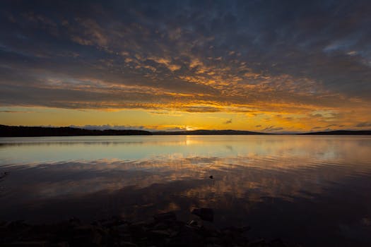 Captivating sunset view reflecting on a serene lake in Ludvika, Dalarnas län, Sweden.