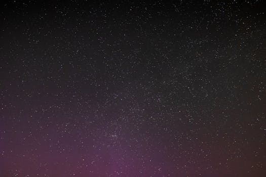 A breathtaking star-filled night sky featuring a subtle purple aurora glow, perfect for serene backgrounds.