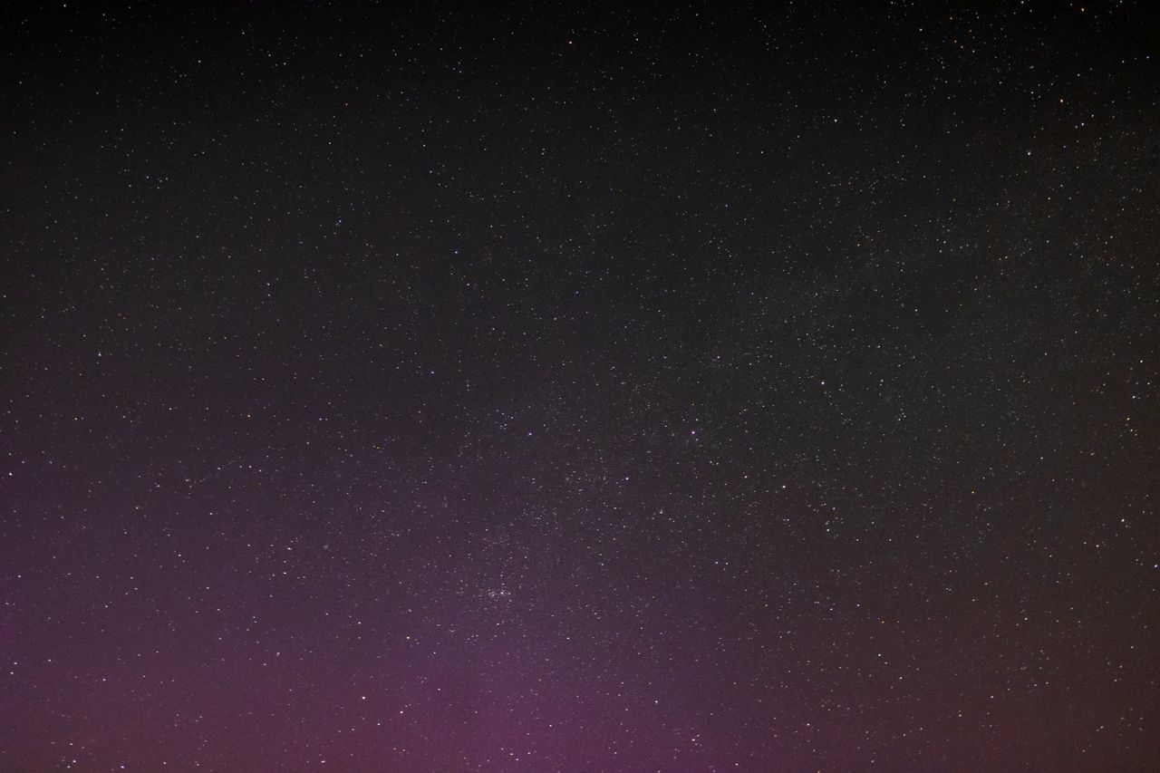 a breathtaking star filled night sky featuring a subtle purple aurora
