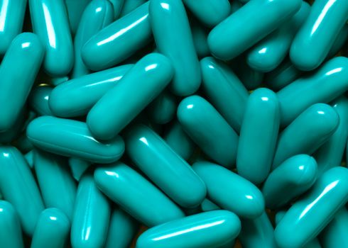 Close-up of turquoise capsules, ideal for pharmaceutical themes.