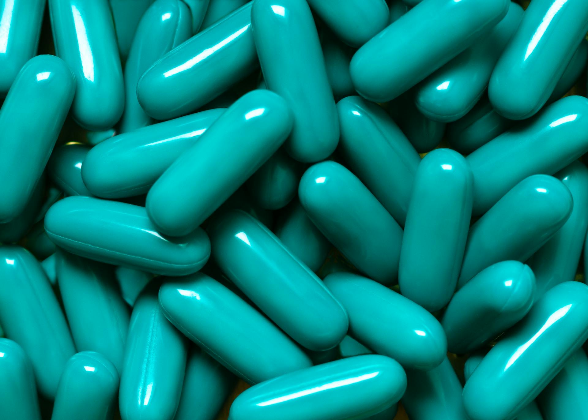 A bunch of turquoise pharmaceutical capsules