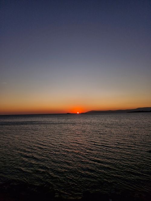 Free A breathtaking ocean sunset with vibrant colors and calming waves. Stock Photo