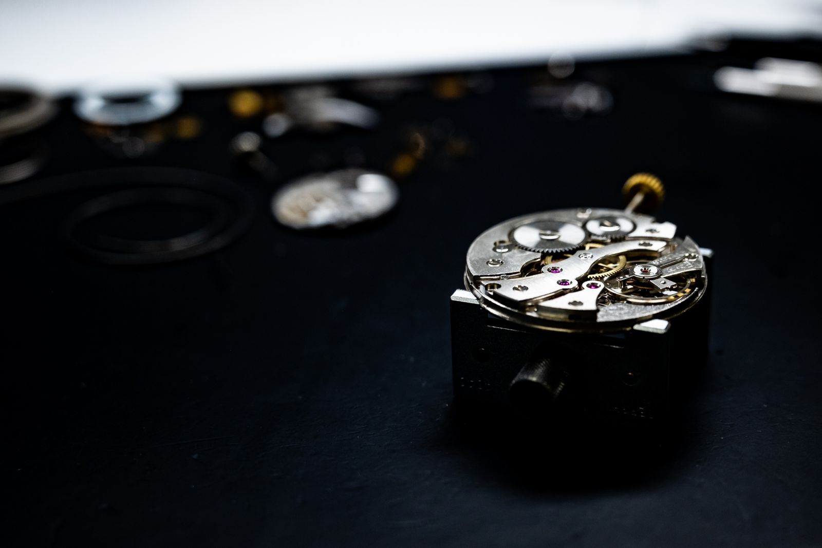 Open watch movement parts on a dark surface