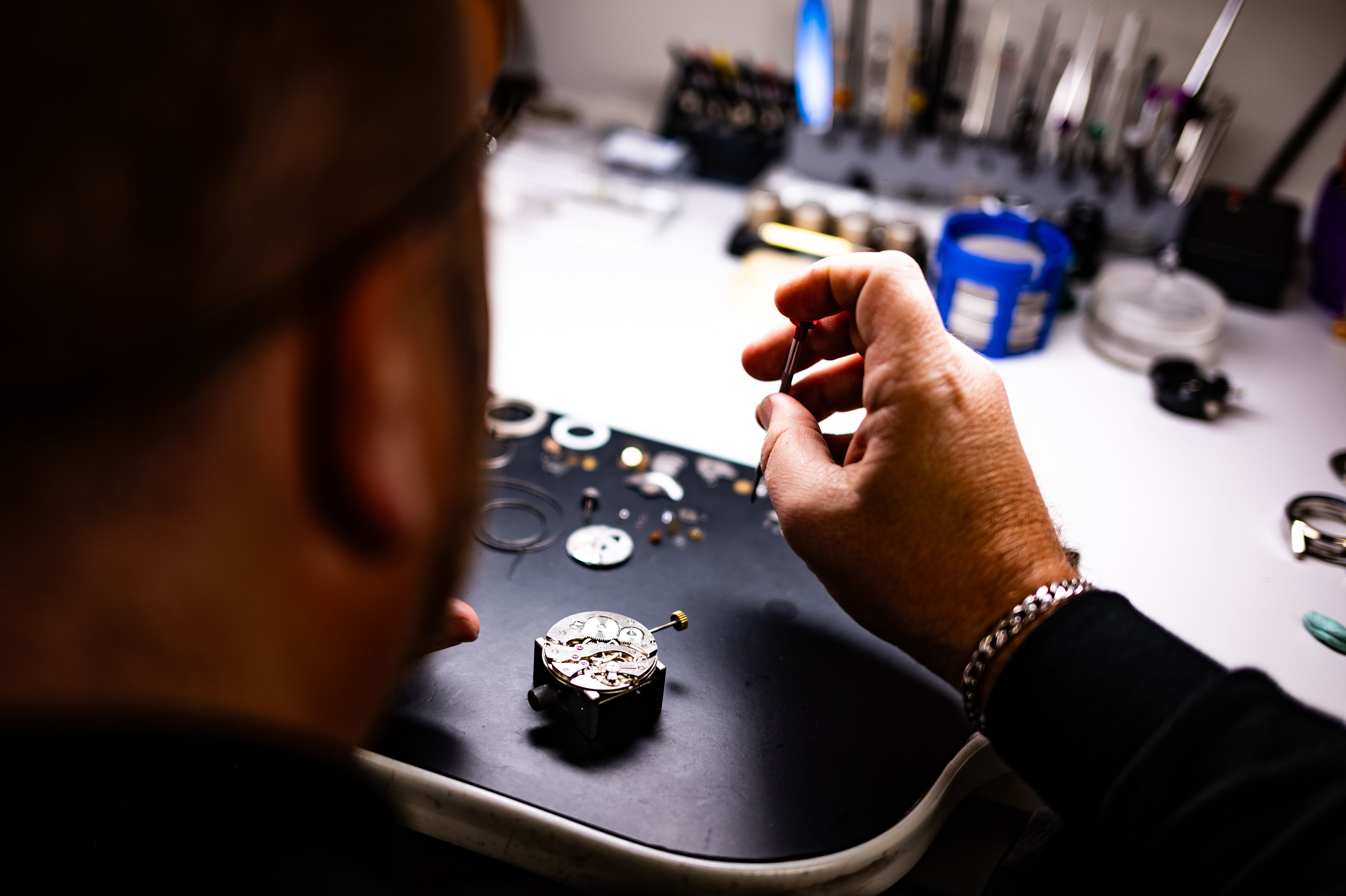 Watchmaker carefully assembling a mechanical watch, demonstrating precision and craftsmanship.