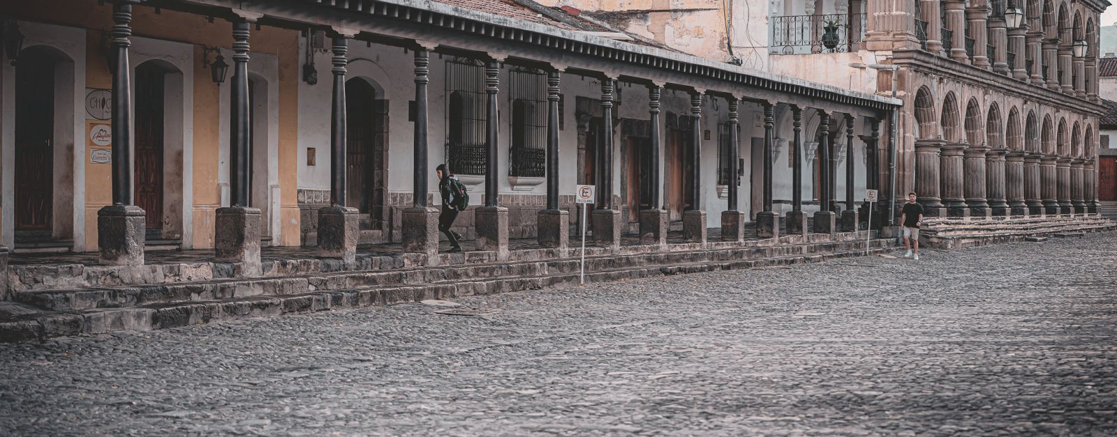 Elegant colonial buildings with stone archways and cobblestone streets in Antigua Guatemala.