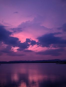 Stunning purple sunset reflecting over a serene lake, creating a dramatic landscape scene.