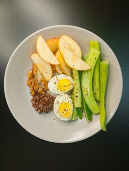 A nutritious and balanced breakfast bowl featuring eggs, fruits, and vegetables.