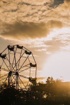在壮丽的日落天空映衬下，雄伟的摩天轮矗立于多拉多游乐场