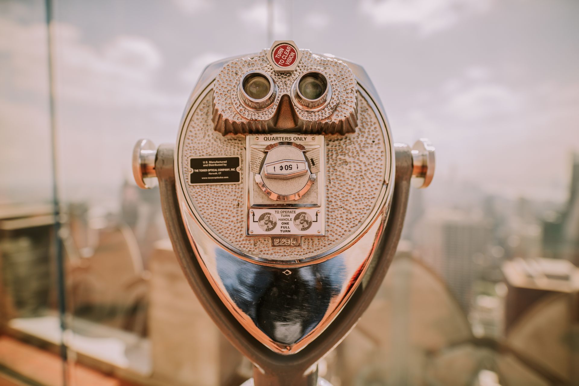 Coin operated telescope overlooking the New York City skyline on a sunny day, vintage feel.