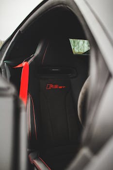 Close-up of a luxury sports car interior featuring a black and red sport seat.