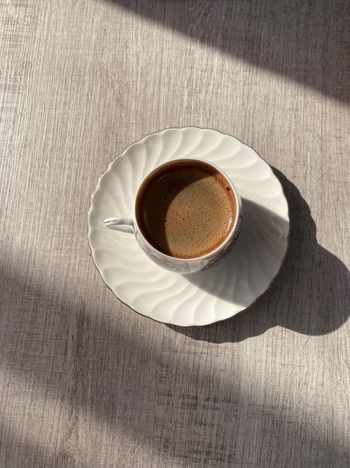 Free Warm sunlight on a coffee cup with rich, espresso foam. Stock Photo