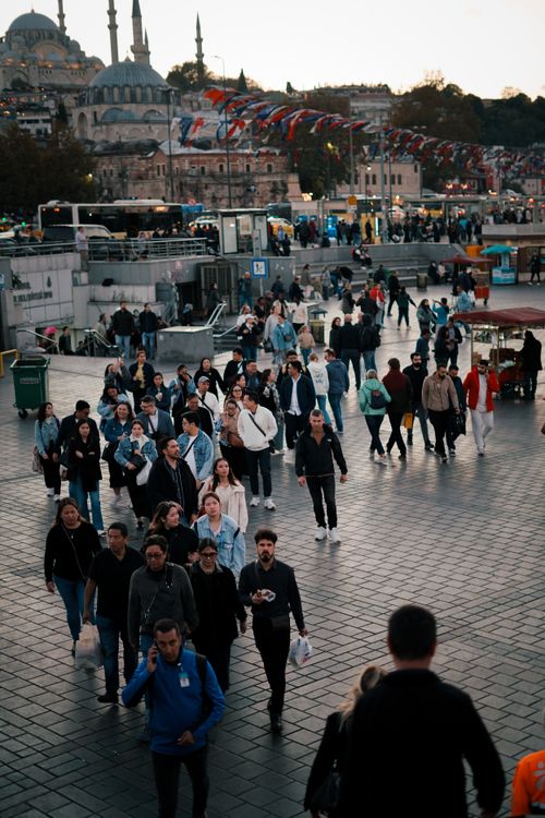 Free A lively scene of people walking through a popular square in Istanbul, Turkey, during the evening. Stock Photo
