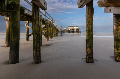Free View of the iconic wooden pier on the sandy shores of Sankt Peter-Ording, Schleswig-Holstein. Stock Photo
