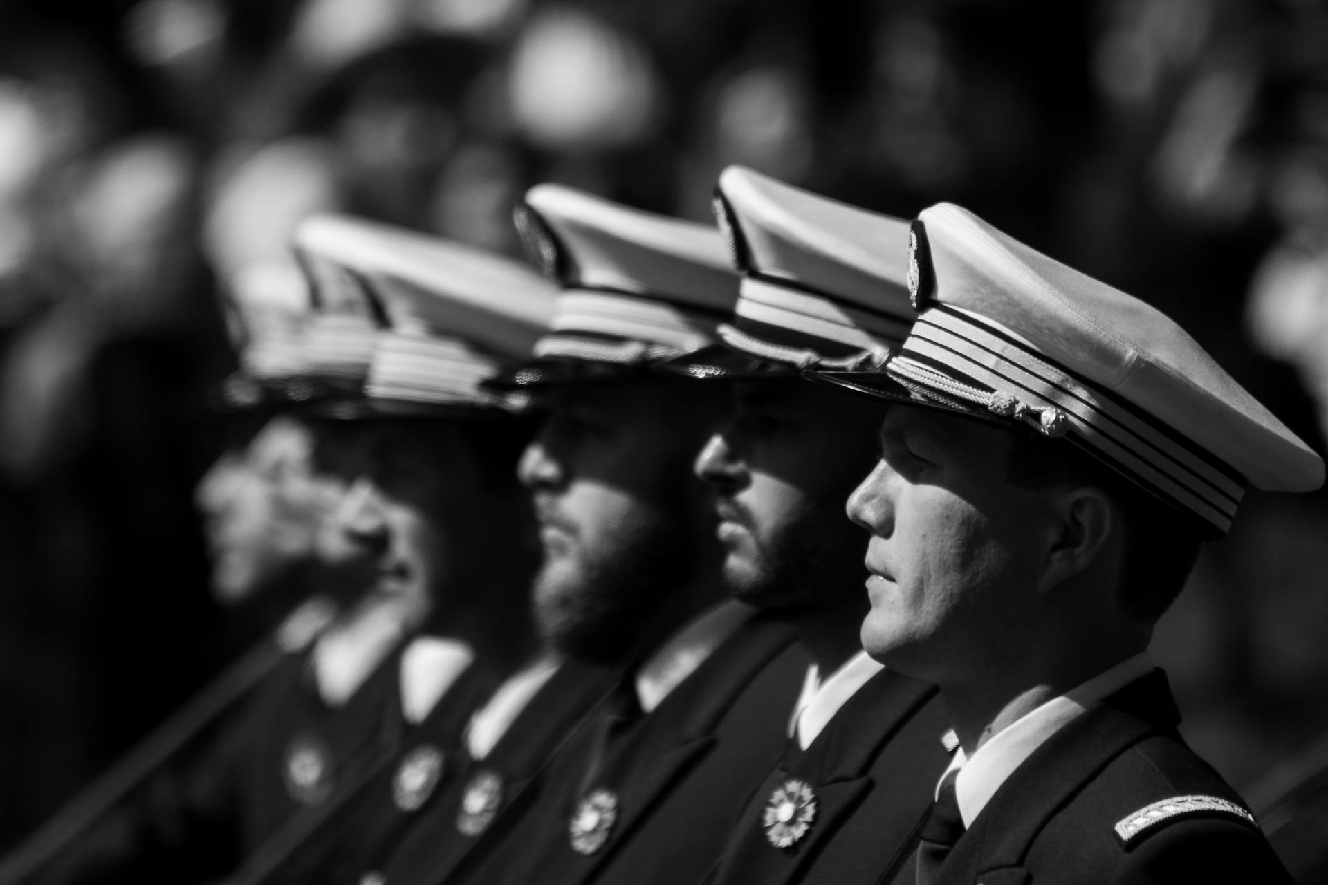 Black and white photo of navy officers in formation during a ceremony, highlighting discipline.