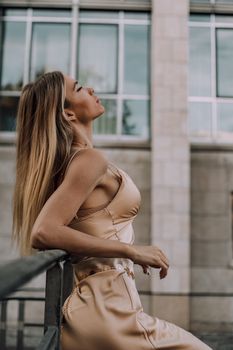 Stylish woman in satin dress posing outdoors in Munich, showcasing elegance and fashion.