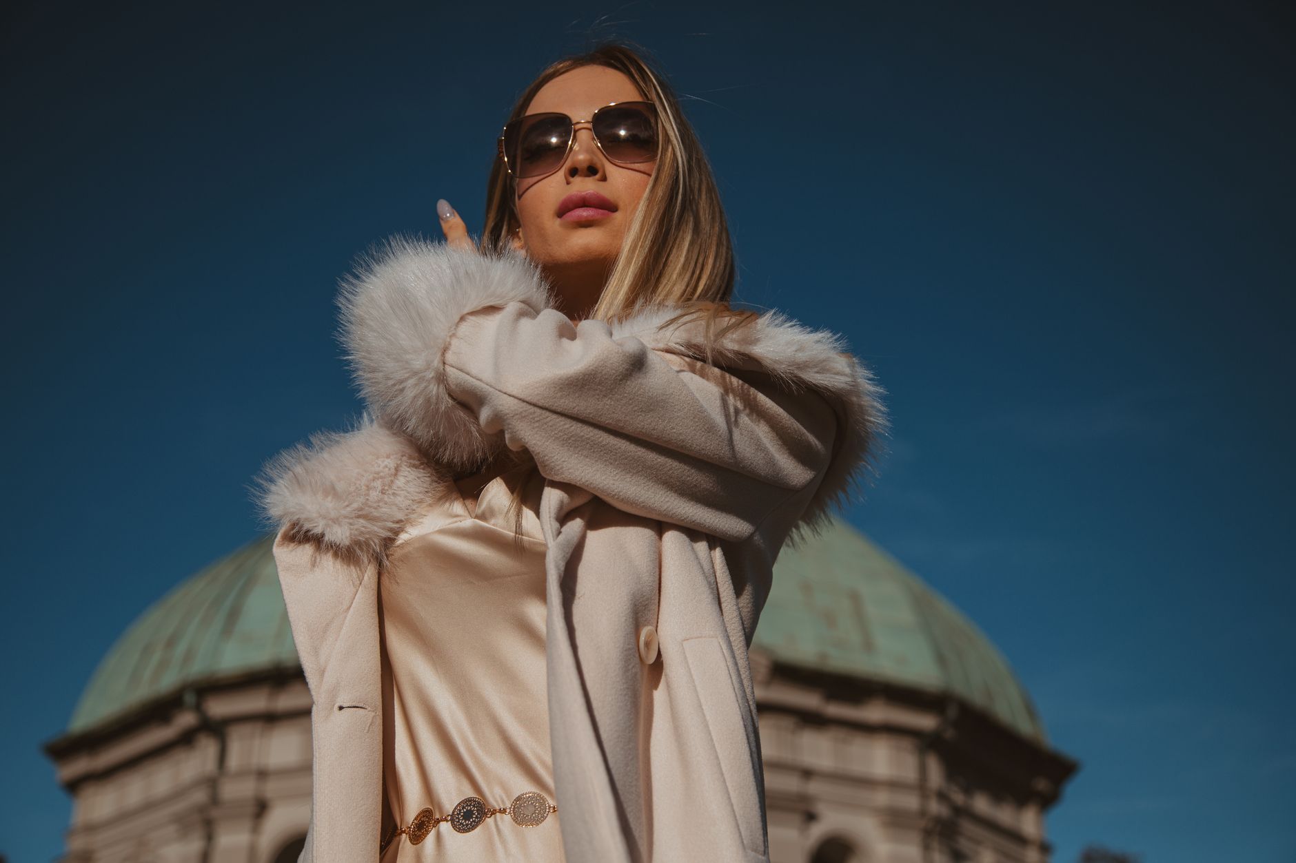 Stylish woman in a fur-trimmed coat posing confidently outdoors in München.