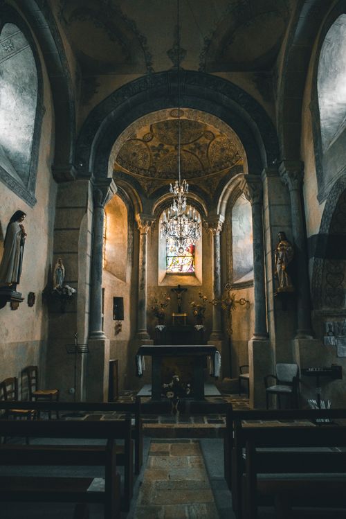 Free A captivating view of a historic church interior showcasing intricate architecture and stained glass. Stock Photo