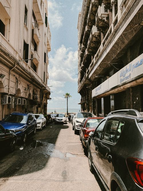 Free Explore a vintage city street view in Alexandria with parked cars and vibrant blue sky. Stock Photo