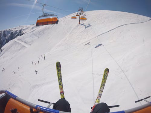 Person Wearing Snow Ski Riding A Cable Car