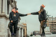 Two masked figures in an urban setting demonstrating street dance artistry and creativity.