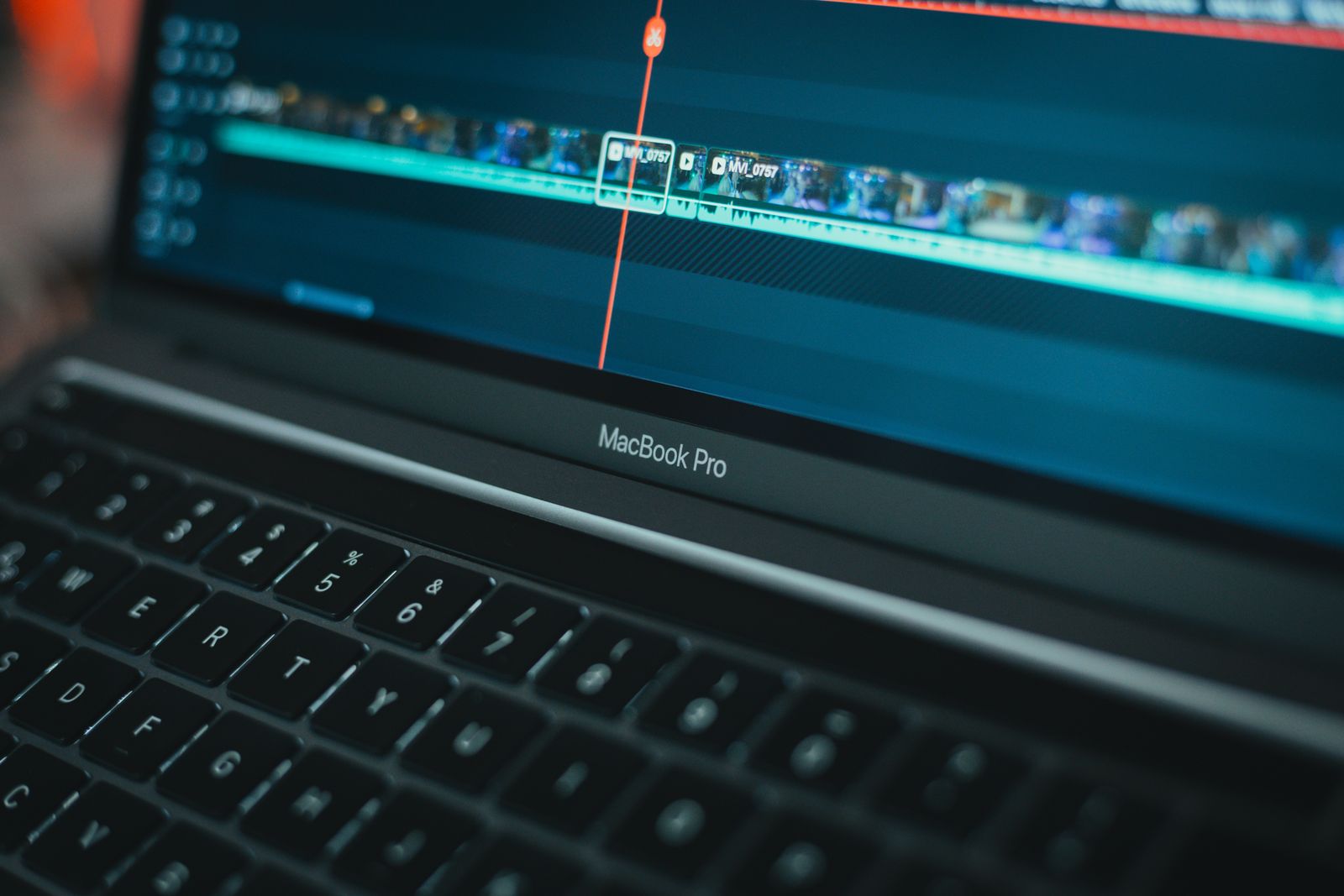 A close-up of an editing timeline with audio waveforms on a laptop screen
