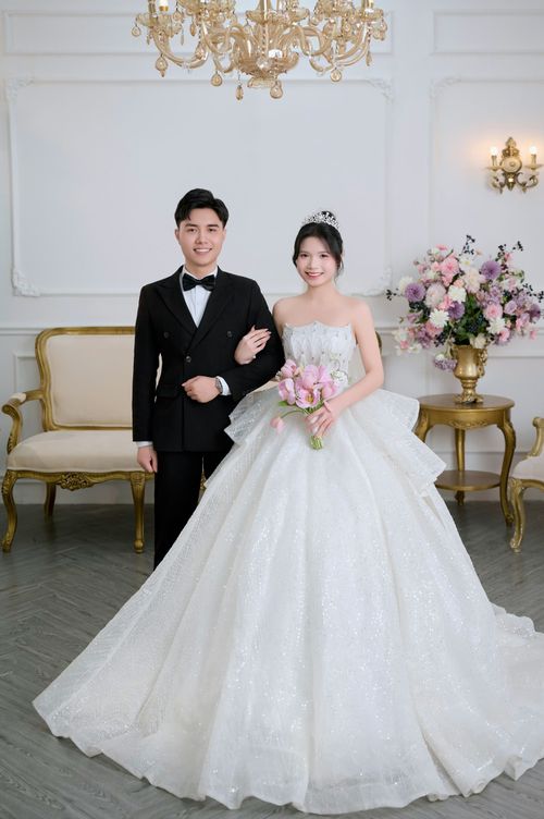 Free Classic wedding portrait with bride in gown and groom in tuxedo, elegant setting. Stock Photo