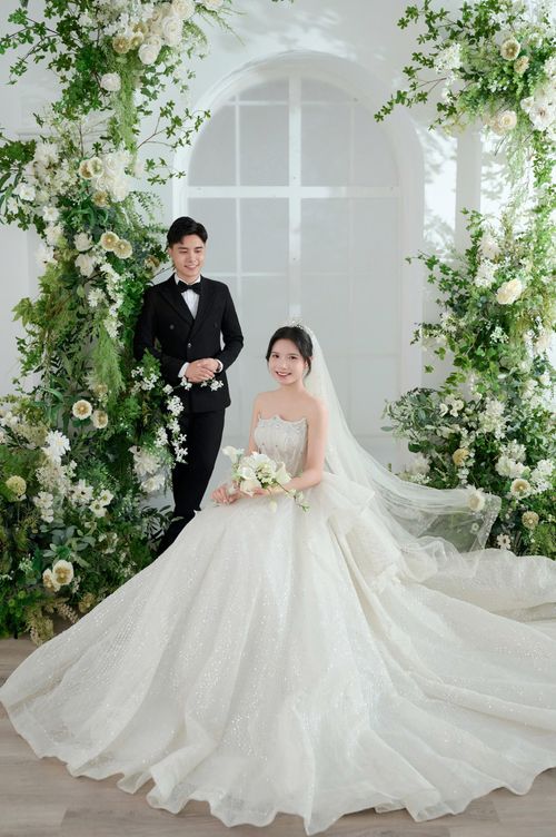 Free Beautiful wedding portrait of a couple in Hải Dương with lush floral decorations. Stock Photo
