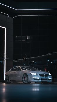 Elegant silver sedan parked in a sleek urban environment under soft night lighting.