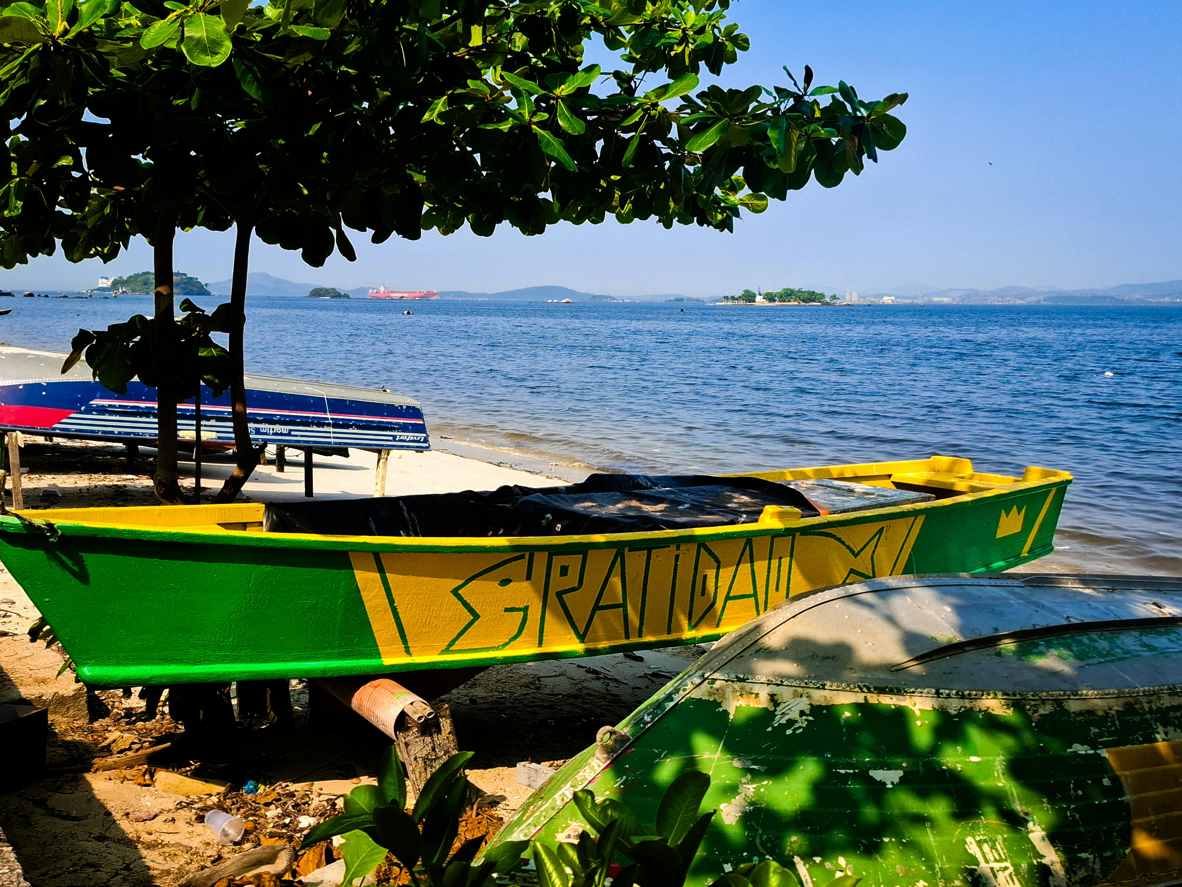 A vibrant yellow and green boat on a sunny beach in Rio de Janeiro, perfect for tropical escapades.