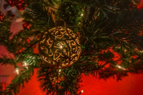 Free A warm and festive close-up of a decorative Christmas ornament on a tree. Stock Photo