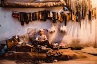 在巴基斯坦拉合尔的城市街头，一个充满活力的小贩场景中，一个孩子正在卖凉鞋