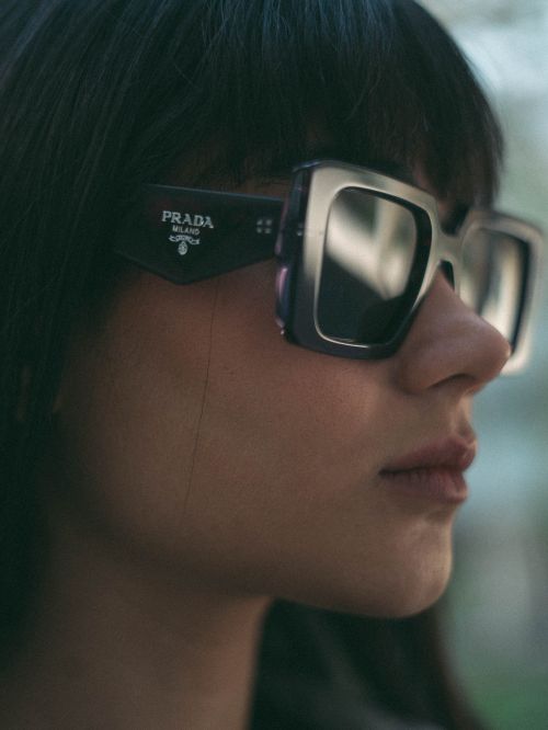 Free Close-up portrait of a stylish woman in Prada sunglasses, exuding fashion and luxury. Stock Photo