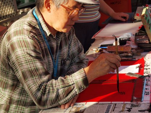 Free Asian craftsman demonstrates traditional Chinese calligraphy art. Stock Photo