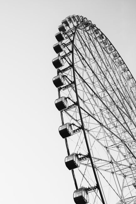 A striking black and white image of a ferris wheel with a clear sky backdrop.