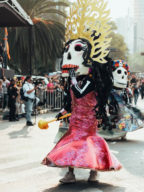 Free Colorful Day of the Dead parade featuring traditional costumes in Mexico City. Stock Photo