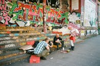 三个成年人在涂鸦遍布的街道上互动，拥抱城市文化与艺术