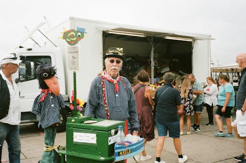 Man Standing Behind Green Bin