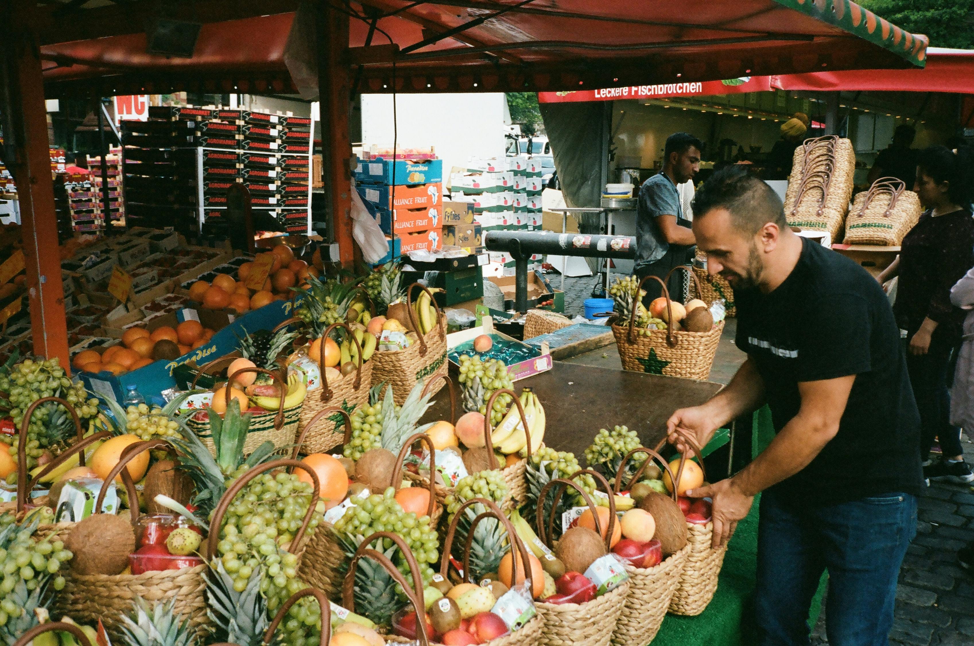 Man Fixing Basket of Fruits on Table