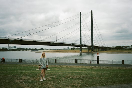 市区河上吊桥上的女人在阴天里