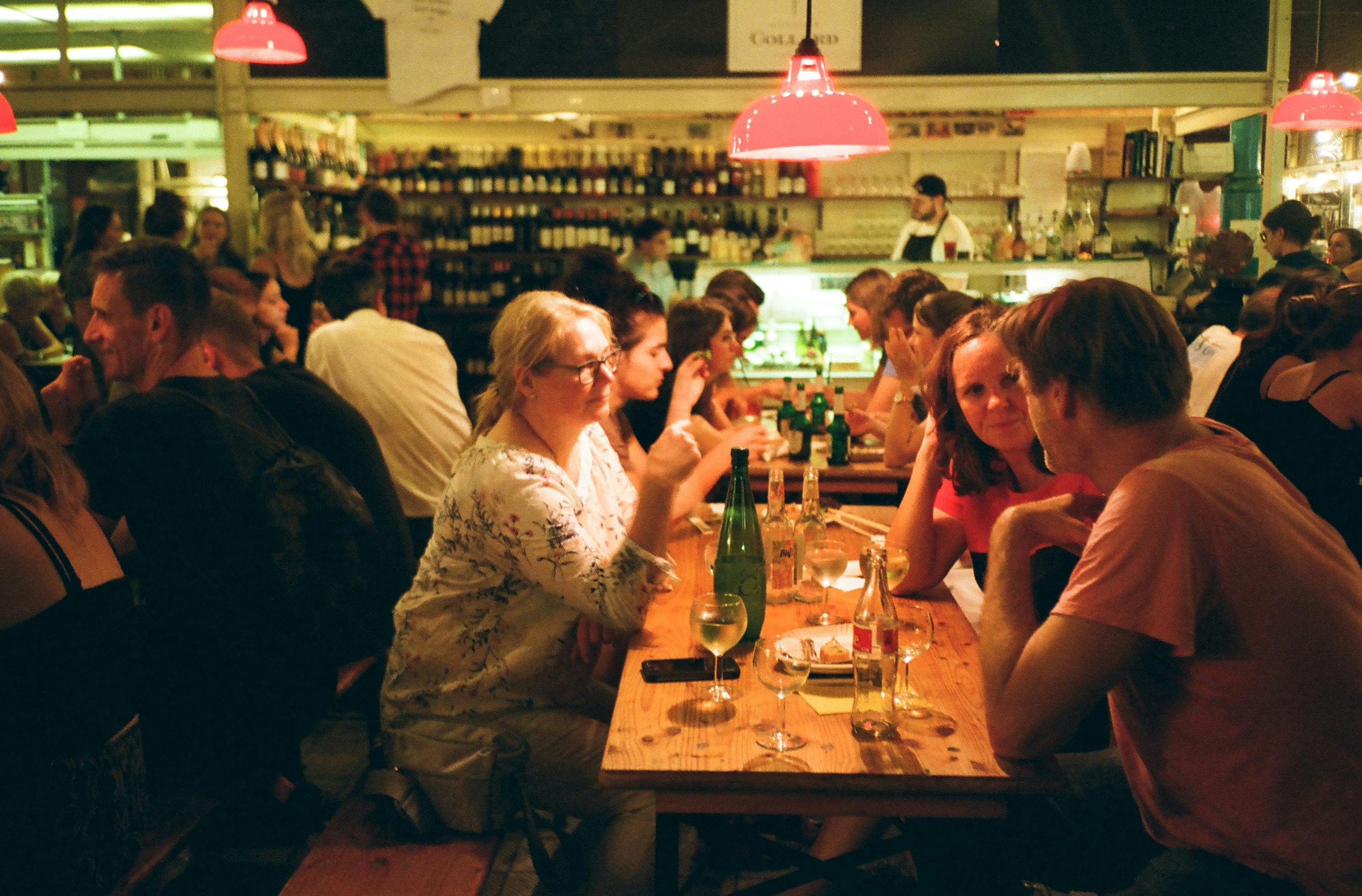 People Sitting In Front Of Rectangular Wooden Table