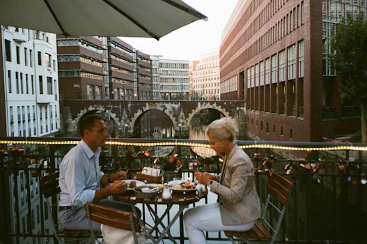 一对夫妇在一家户外餐厅享用晚餐，那里可以俯瞰风景优美的运河和城市建筑