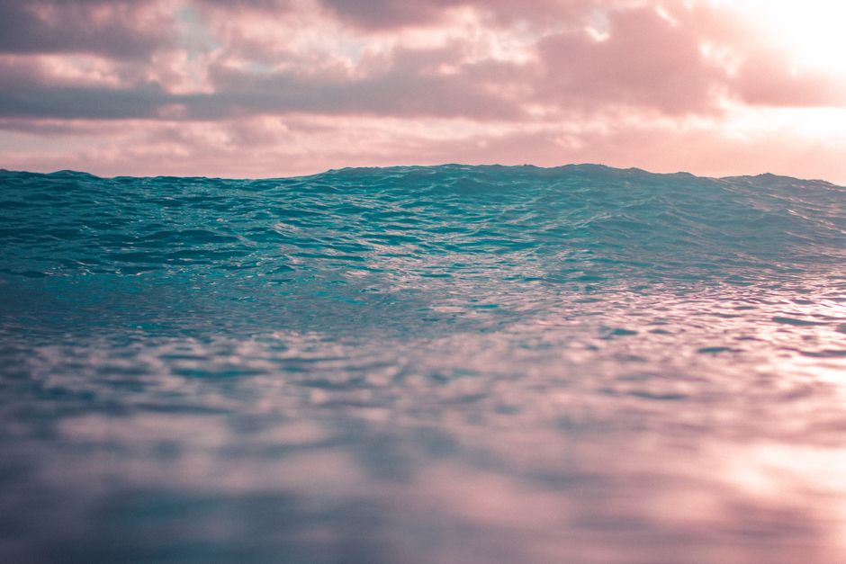 Calm ocean wave during a beautiful sunset in Hawaii, showcasing serene ocean beauty.