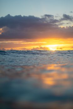 Capture the serene beauty of a Hawaiian sunset with tranquil ocean waves and vibrant colors.
