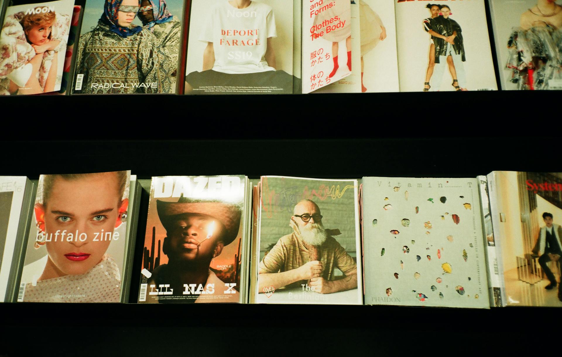 Colorful assortment of fashion magazines displayed on a retail shelf in a bookstore.