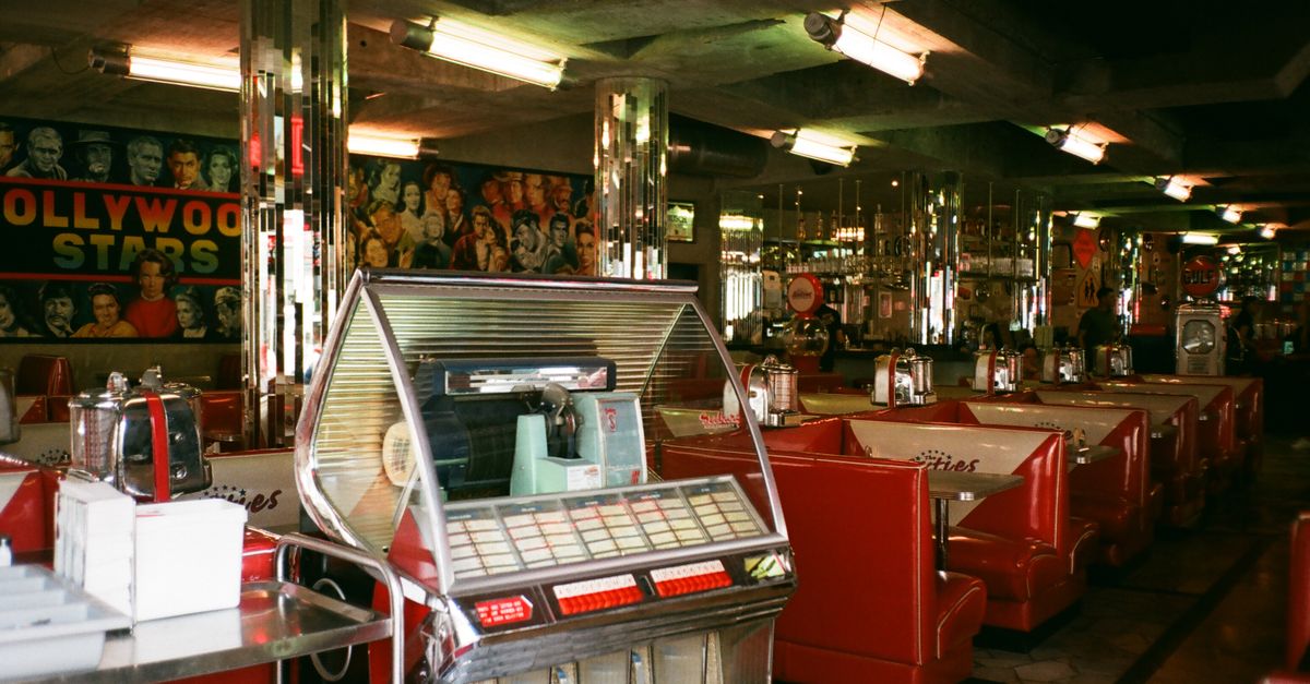 Vintage diner interior with neon sign and booths filled with young people