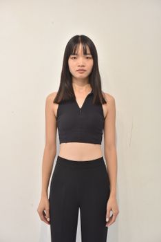 Portrait of a woman in black athletic outfit on a neutral background.